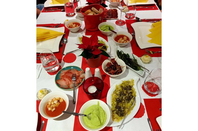 Ein Tisch mit verschiedenen Tapas, darunter Guacamole, Paprika und Brot. Festliche Dekoration mit roten Servietten und Weihnachtssternen., &copy; Kultweine-Kochwelten-Kunst&uuml;cke - Kochschule Sonja Lenz