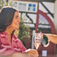Ein Paar genie&szlig;t Sekt im Freien vor einem Fachwerkhaus. Der Mann schenkt der Frau ein Glas ein, w&auml;hrend sie l&auml;chelt., &copy; Esslinger Stadtmarketing & Tourismus GmbH