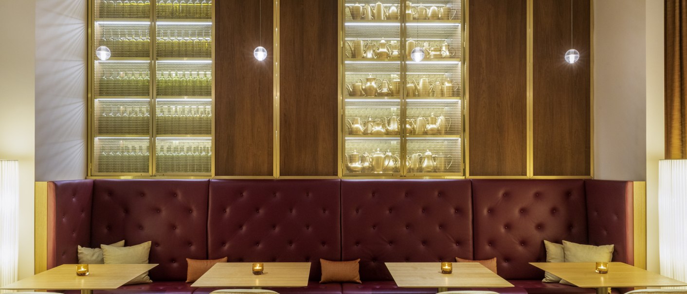 Elegante Bar mit roten Sitzbänken, Holztischen und beleuchteten Regalen voller Gläser und Karaffen. Dezente Beleuchtung schafft eine gemütliche Atmosphäre., © Mövenpick Hotel Stuttgart Messe & Congress Elegante Bar mit roten Sitzbänken, Holztischen und beleuchteten Regalen voller Gläser und Karaffen. Dezente Beleuchtung schafft eine gemütliche Atmosphäre., © Mövenpick Hotel Stuttgart Messe & Congress