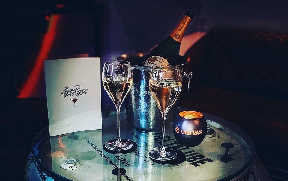 Tisch in der MelRose Bar mit Champagnergl&auml;sern, Flasche im Eisk&uuml;bel und Kerze. Elegante Atmosph&auml;re., &copy; MelRose Bar