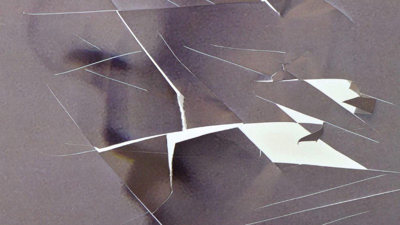 Abstrakte Komposition aus zerrissenen Papierstücken auf grauem Hintergrund, die eine komplexe, vielschichtige Struktur bilden., © Die verlorene Ehre der Katharina Blum oder: Wie Gewalt entstehen und wohin sie führen kann