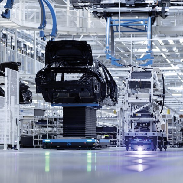 Eine moderne Fabrikhalle zeigt die Fahrzeugmontage mit Robotern und Fahrzeugkarosserien. Die Umgebung ist hell und technologisch fortschrittlich., © Mercedes-Benz AG Eine moderne Fabrikhalle zeigt die Fahrzeugmontage mit Robotern und Fahrzeugkarosserien. Die Umgebung ist hell und technologisch fortschrittlich., © Mercedes-Benz AG