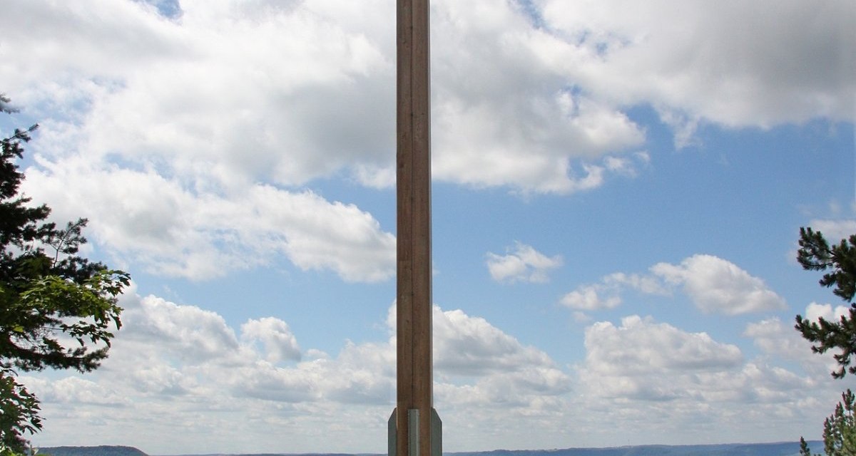 Ein großes Holzkreuz steht auf einem Hügel. Menschen stehen daneben und genießen die Aussicht auf die Landschaft und den blauen Himmel mit Wolken., © Foto Friedrich Kopper Ein großes Holzkreuz steht auf einem Hügel. Menschen stehen daneben und genießen die Aussicht auf die Landschaft und den blauen Himmel mit Wolken., © Foto Friedrich Kopper