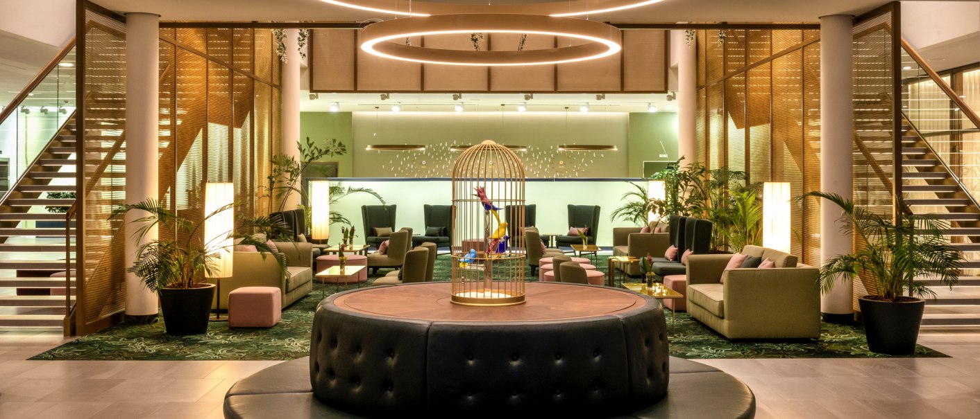 Elegante Hotellobby mit runden Sitzgelegenheiten, Pflanzen und stilvollen Leuchten. Im Hintergrund sind Treppen und gemütliche Sitzbereiche zu sehen., © Mövenpick Hotel Stuttgart Messe & Congress Elegante Hotellobby mit runden Sitzgelegenheiten, Pflanzen und stilvollen Leuchten. Im Hintergrund sind Treppen und gemütliche Sitzbereiche zu sehen., © Mövenpick Hotel Stuttgart Messe & Congress