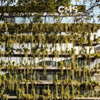 Ein modernes Geb&auml;ude mit einer &uuml;ppig begr&uuml;nten Fassade und gro&szlig;en Glasfenstern. Pflanzen h&auml;ngen von den Etagen herab., &copy; Stuttgart-Marketing GmbH, Sarah Schmid