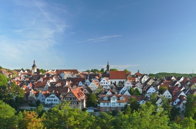 Panorama einer Stadt mit vielen Fachwerkh&auml;usern und Kircht&uuml;rmen, umgeben von gr&uuml;nen B&auml;umen, unter einem klaren blauen Himmel., &copy; Stadtverwaltung Marbach am Neckar