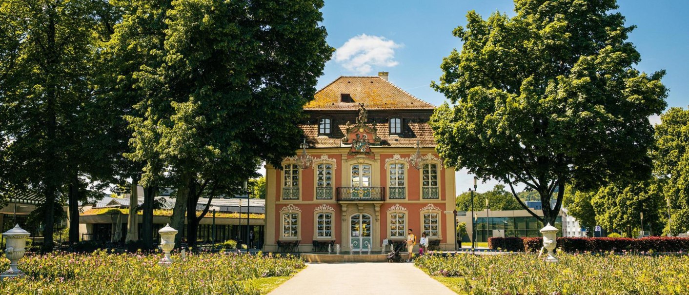 Das Rokokoschlösschen in Schwäbisch Gmünd, umgeben von blühenden Gärten und hohen Bäumen, bei sonnigem Wetter., © SMG, Sarah Schmid Das Rokokoschlösschen in Schwäbisch Gmünd, umgeben von blühenden Gärten und hohen Bäumen, bei sonnigem Wetter., © SMG, Sarah Schmid