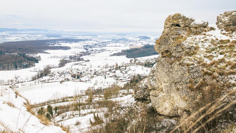 Ein winterlicher Ausblick von einem Felsen auf eine schneebedeckte Landschaft mit Feldern und W&auml;ldern im Hintergrund., &copy; Stuttgart-Marketing GmbH, Sarah Schmid