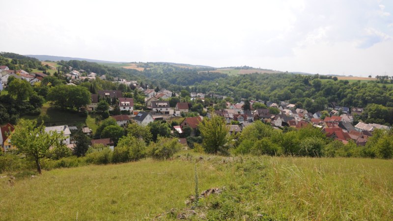 Panoramablick auf ein Dorf mit vielen H&auml;usern, umgeben von gr&uuml;ner Landschaft und H&uuml;geln unter einem bew&ouml;lkten Himmel., &copy; Land der 1000 H&uuml;gel - Kraichgau-Stromberg