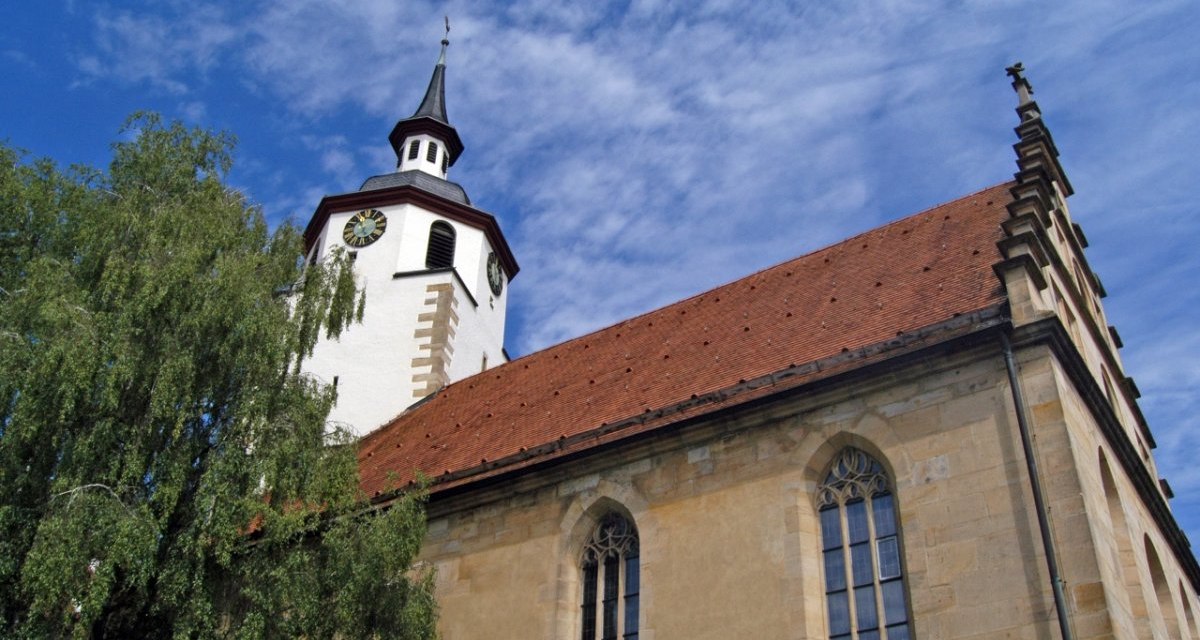 Kirchturm mit Uhr und rotem Dach, flankiert von einem Baum, vor blauem Himmel mit Wolken., &copy; Natur.Nah. Sch&ouml;nbuch & Heckeng&auml;u