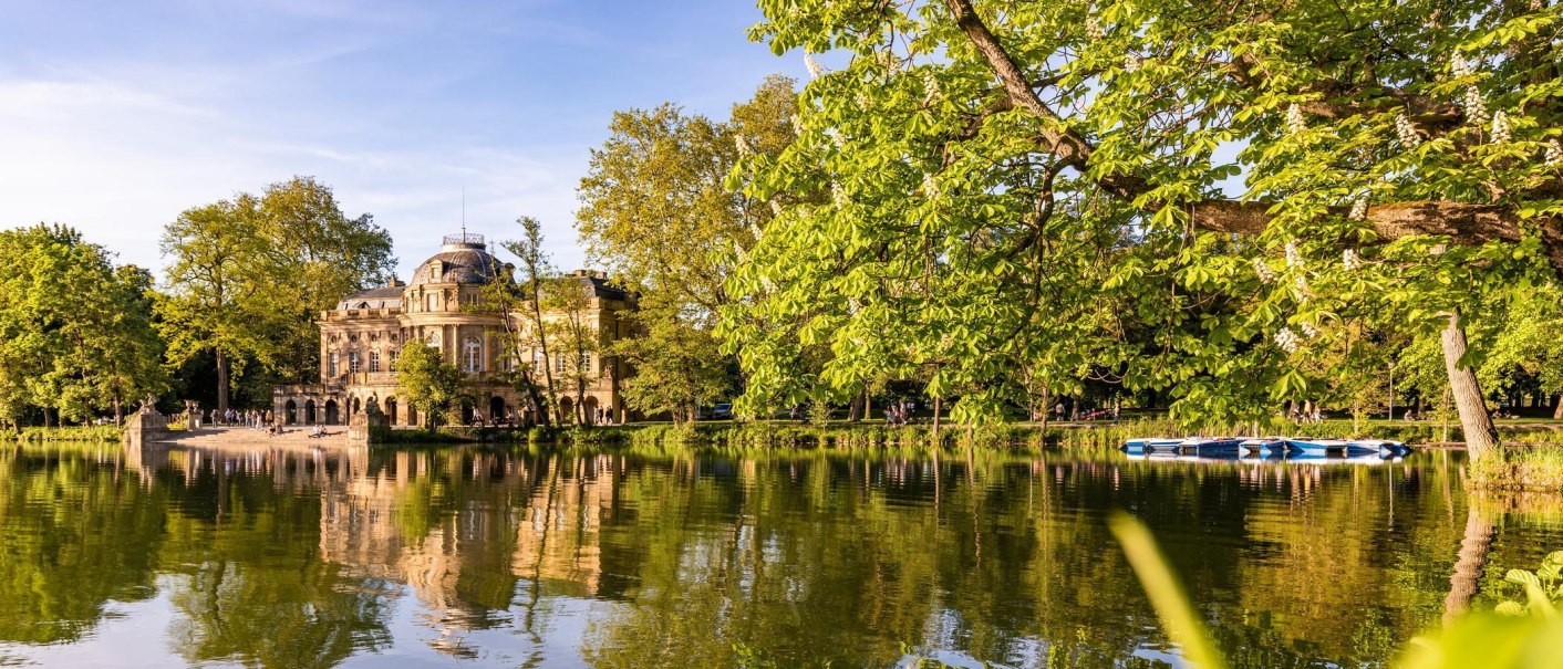 Schloss Monrepos spiegelt sich im ruhigen See, umgeben von üppigem Grün und strahlendem Sonnenschein. Ein idyllisches Bild der Natur und Architektur., © SMG, Werner Dieterich Schloss Monrepos spiegelt sich im ruhigen See, umgeben von üppigem Grün und strahlendem Sonnenschein. Ein idyllisches Bild der Natur und Architektur., © SMG, Werner Dieterich