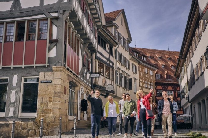 Eine Gruppe von Menschen spaziert durch eine Altstadt mit Fachwerkhäusern. Sie wirken fröhlich und interessiert., © Esslinger Stadtmarketing &amp; Tourismus GmbH