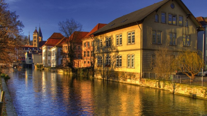 Historische Gebäude am Fluss in der Altstadt von Esslingen, beleuchtet von der Abendsonne. Im Hintergrund ist ein Kirchturm zu sehen., © Stuttgart-Marketing GmbH Historische Gebäude am Fluss in der Altstadt von Esslingen, beleuchtet von der Abendsonne. Im Hintergrund ist ein Kirchturm zu sehen., © Stuttgart-Marketing GmbH
