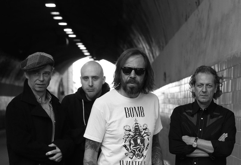 Vier Männer posieren in einem Tunnel. Einer trägt ein T-Shirt mit der Aufschrift 'BOMB'. Die Szene ist in Schwarz-Weiß gehalten., © Kulturverein Resus e.V.