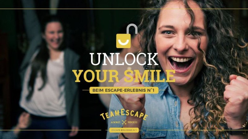 Frau jubelt mit geballten Fäusten, im Hintergrund weitere feiernde Personen. Text: "Unlock Your Smile" und "TeamEscape"., © TeamEscape Stuttgart