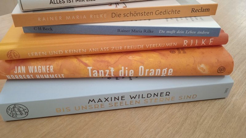 Ein Stapel Bücher mit Werken von Rainer Maria Rilke und anderen Autoren liegt auf einem Holztisch., © Kulturforum Schorndorf e. V. Ein Stapel Bücher mit Werken von Rainer Maria Rilke und anderen Autoren liegt auf einem Holztisch., © Kulturforum Schorndorf e. V.