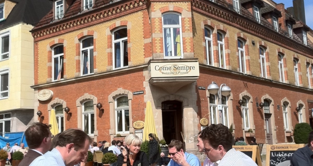Menschen genießen das sonnige Wetter an einem Tisch vor dem historischen Gebäude 'Come Sempre' am Wettbachplatz in Sindelfingen., © Sindelfingen - Stuttgart-Marketing GmbH