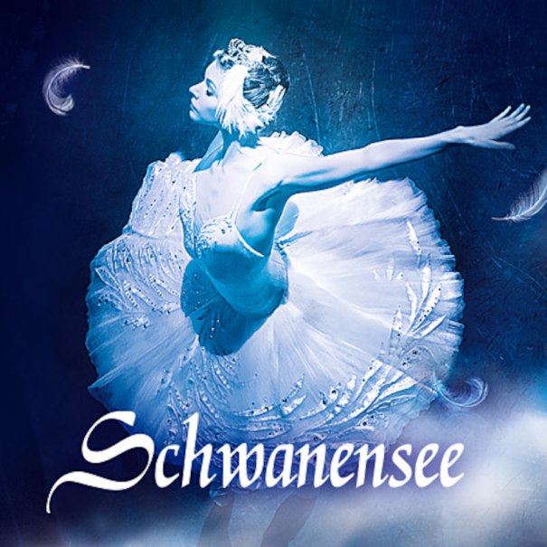 Eine Ballerina in einem weißen Tutu tanzt anmutig auf der Bühne, umgeben von blauen Lichteffekten und schwebenden Federn., © P.T.F. GmbH-Konzertagentur Friedmann Eine Ballerina in einem weißen Tutu tanzt anmutig auf der Bühne, umgeben von blauen Lichteffekten und schwebenden Federn., © P.T.F. GmbH-Konzertagentur Friedmann