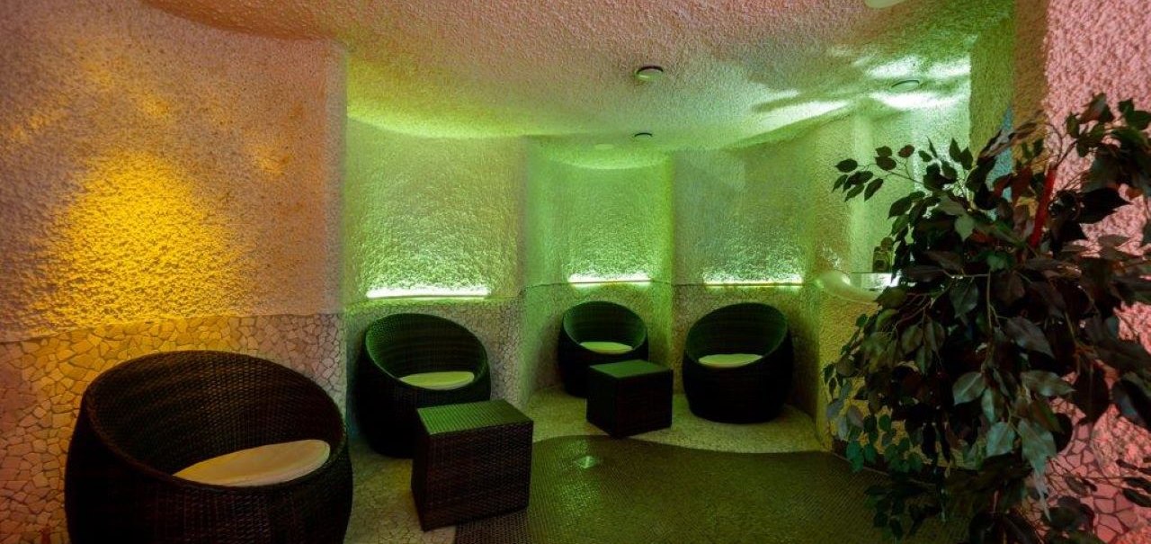 Ein gemütlicher Wellnessbereich mit runden Korbsesseln, gedämpfter Beleuchtung in warmen Farben und einer Pflanze in der Ecke., © Kronen Hotel GmbH