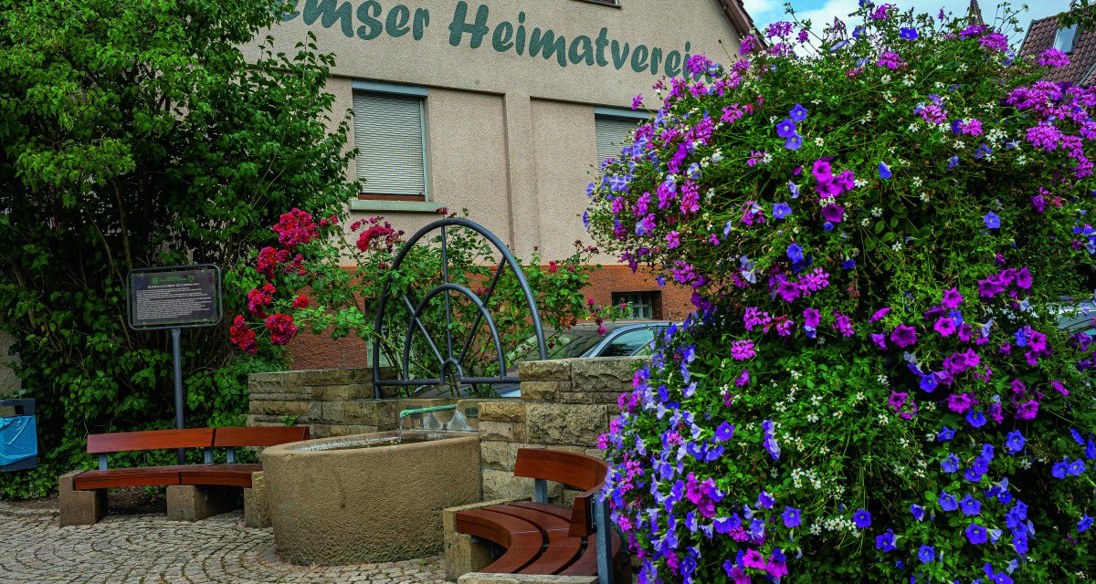 Blumenreicher Platz mit Brunnen und Bänken vor einem Gebäude des Heimatvereins in Remseck am Neckar. Blumenreicher Platz mit Brunnen und Bänken vor einem Gebäude des Heimatvereins in Remseck am Neckar.