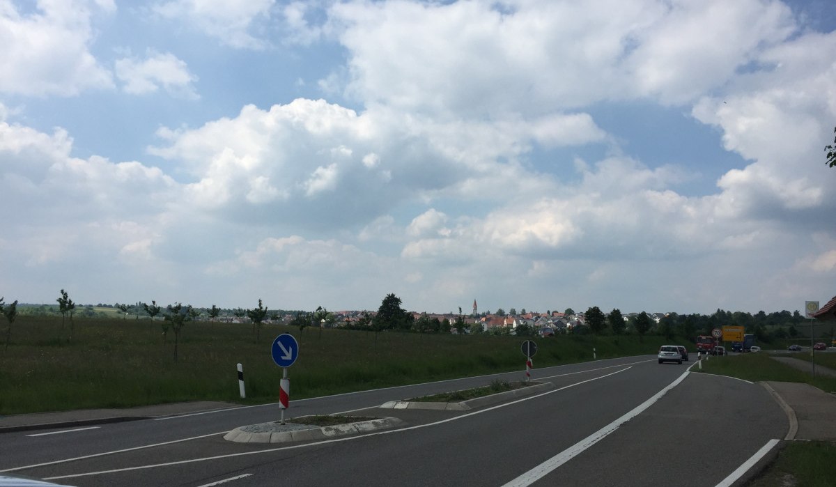 Landstraße mit Autos, umgeben von Wiesen. Im Hintergrund ist eine Stadt zu sehen, der Himmel ist bewölkt., © www.pro-cycl.de Landstraße mit Autos, umgeben von Wiesen. Im Hintergrund ist eine Stadt zu sehen, der Himmel ist bewölkt., © www.pro-cycl.de