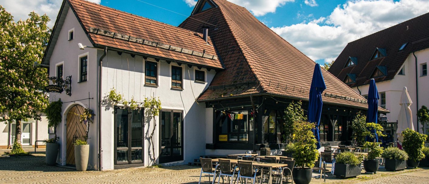 Traditionelles Gebäude mit Ziegeldach und Restaurant auf dem Kelterplatz in Metzingen. Sonnenschirme und Tische im Freien, umgeben von Pflanzen., © Stuttgart-Marketing GmbH, Sarah Schmid Traditionelles Gebäude mit Ziegeldach und Restaurant auf dem Kelterplatz in Metzingen. Sonnenschirme und Tische im Freien, umgeben von Pflanzen., © Stuttgart-Marketing GmbH, Sarah Schmid