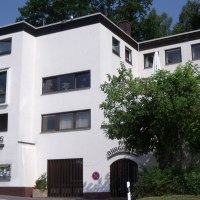 Das Hotel Pfefferburg hat eine weiße Fassade mit großen Fenstern und ist von Bäumen umgeben. Der Schriftzug 'Pfefferburg' ist gut sichtbar., © Landgasthof Hotel Pfefferburg