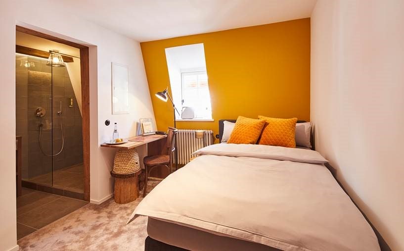 Kleines Schlafzimmer mit gelber Akzentwand, Einzelbett, Schreibtisch und angrenzendem Badezimmer mit Dusche. Helle und gemütliche Atmosphäre., © Hotel Restaurant Bachofer Kleines Schlafzimmer mit gelber Akzentwand, Einzelbett, Schreibtisch und angrenzendem Badezimmer mit Dusche. Helle und gemütliche Atmosphäre., © Hotel Restaurant Bachofer