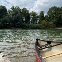 Ein Kanu liegt am Ufer eines ruhigen Flusses, umgeben von dichtem Wald und bew&ouml;lktem Himmel., &copy; Manuel Mattern