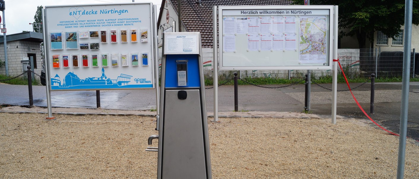 Zwei Informationsschilder am Reisemobilstellplatz Nürtingen mit Stadtinformationen und Karten. Ein Automat steht im Vordergrund., © Stadt Nürtingen, Clint Metzger