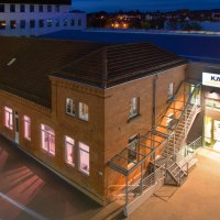 Nachtaufnahme des Kärcher Museums in Winnenden. Ein beleuchtetes Backsteingebäude mit Lichtspuren von Autos im Vordergrund., © SMG Achim Mende