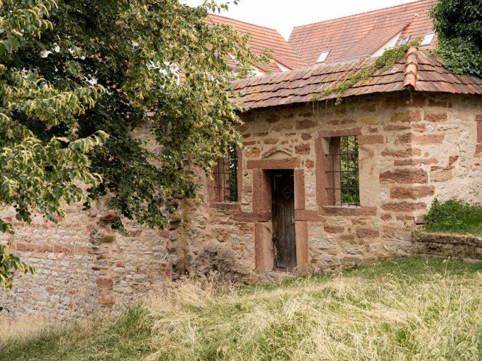 Altes Steingebäude mit Ziegeldach und Holztür, umgeben von Gras und Bäumen. Märchenhafte Atmosphäre., © Stadtverwaltung Weil der Stadt Altes Steingebäude mit Ziegeldach und Holztür, umgeben von Gras und Bäumen. Märchenhafte Atmosphäre., © Stadtverwaltung Weil der Stadt