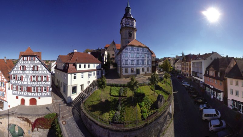 Panorama von Backnang mit Fachwerkhäusern, einem Kirchturm und blühenden Gärten unter strahlend blauem Himmel und Sonnenschein., © Stuttgart-Marketing GmbH Panorama von Backnang mit Fachwerkhäusern, einem Kirchturm und blühenden Gärten unter strahlend blauem Himmel und Sonnenschein., © Stuttgart-Marketing GmbH