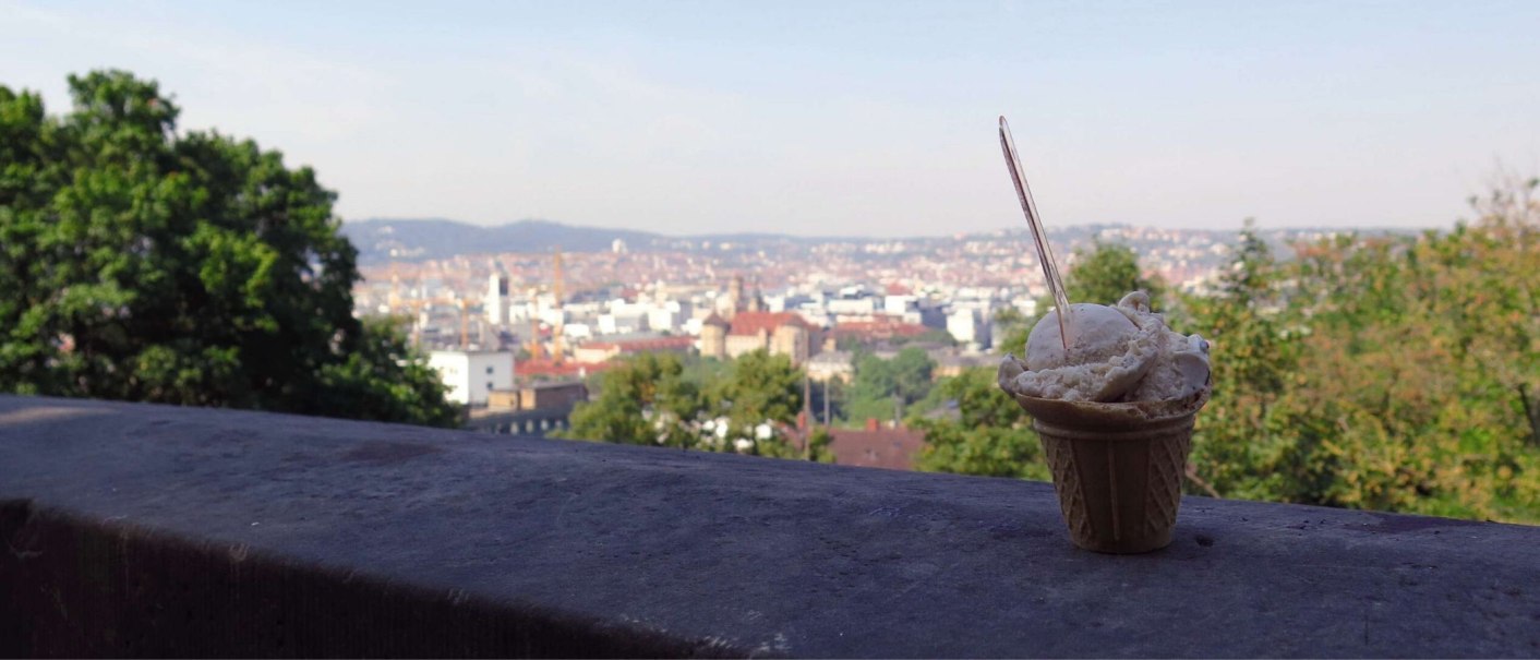 Ein Eisbecher steht auf einer Mauer, im Hintergrund ist eine Stadtlandschaft mit B&auml;umen und Geb&auml;uden zu sehen., &copy; Stuttgart-Marketing GmbH