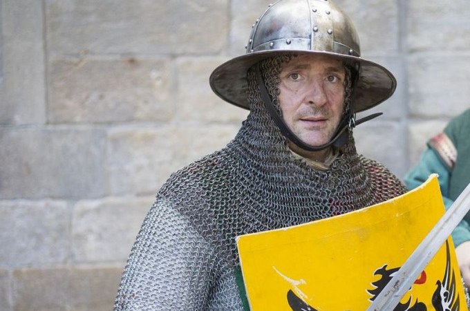 Ein Mann in mittelalterlicher Rüstung mit Kettenhemd und Helm hält ein gelbes Schild mit schwarzem Adler vor einer Steinmauer., © Esslinger Stadtmarketing &amp; Tourismus GmbH
