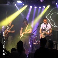 Eine Band performt auf einer B&uuml;hne mit bunten Lichtern. Im Vordergrund ist das Publikum zu sehen., &copy; links im Bild