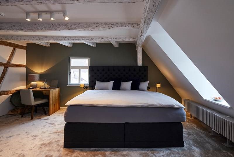 Gemütliches Schlafzimmer mit sichtbaren Holzbalken, großem Bett, Schreibtisch und Dachfenster. Die Wände sind in dunklem Grün gehalten., © Hotel Restaurant Bachofer Gemütliches Schlafzimmer mit sichtbaren Holzbalken, großem Bett, Schreibtisch und Dachfenster. Die Wände sind in dunklem Grün gehalten., © Hotel Restaurant Bachofer